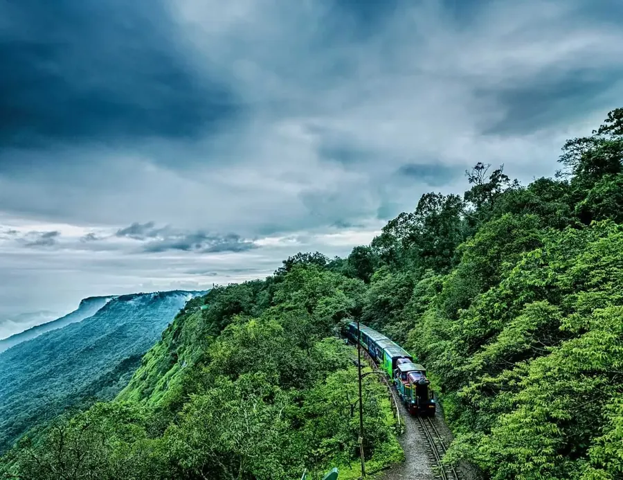 The toy train winding through the forested hills of Matheran