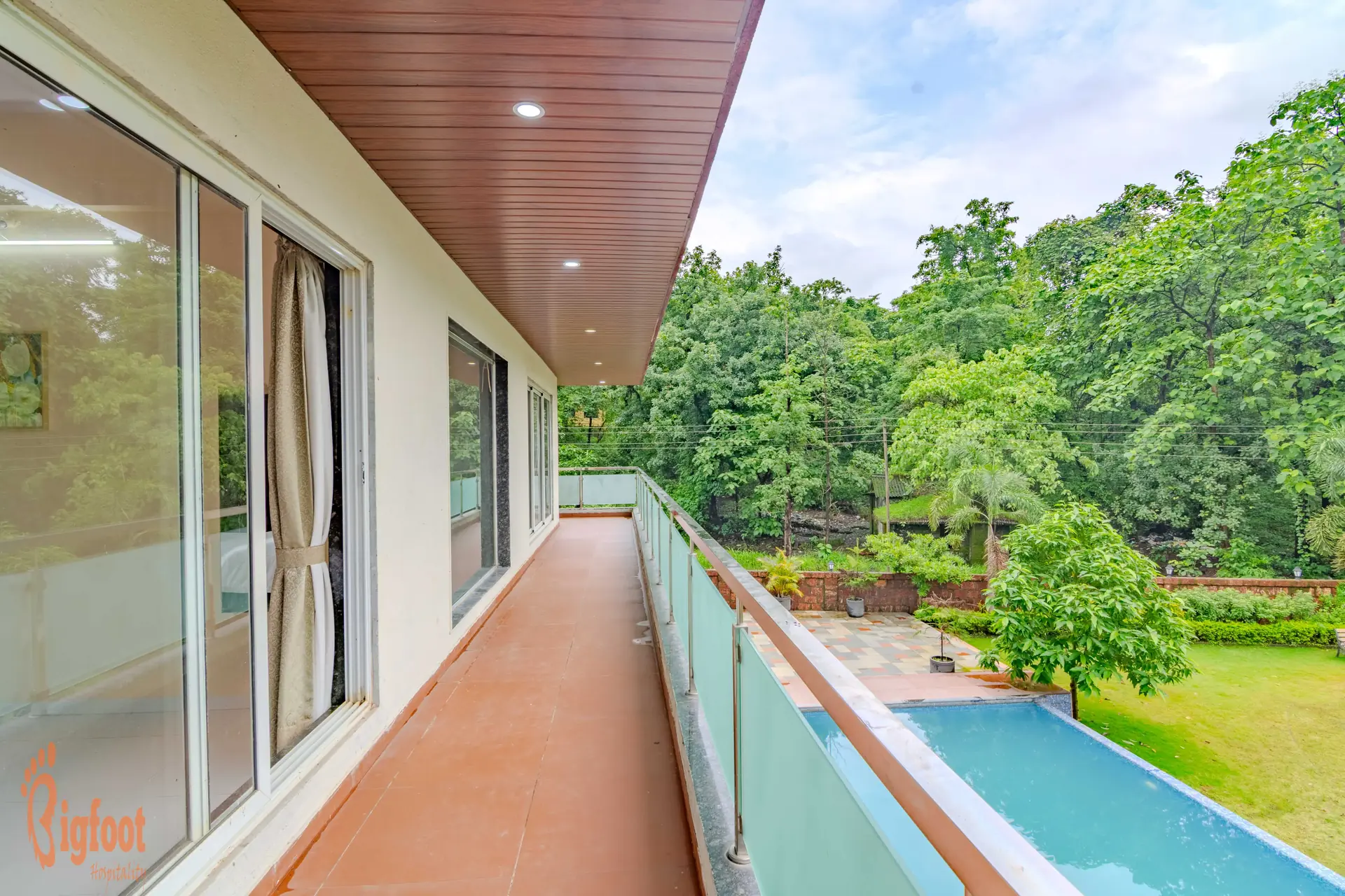 Open balcony corridor at Hideaway Villa overlooking the pool and Sahyadri greenery
