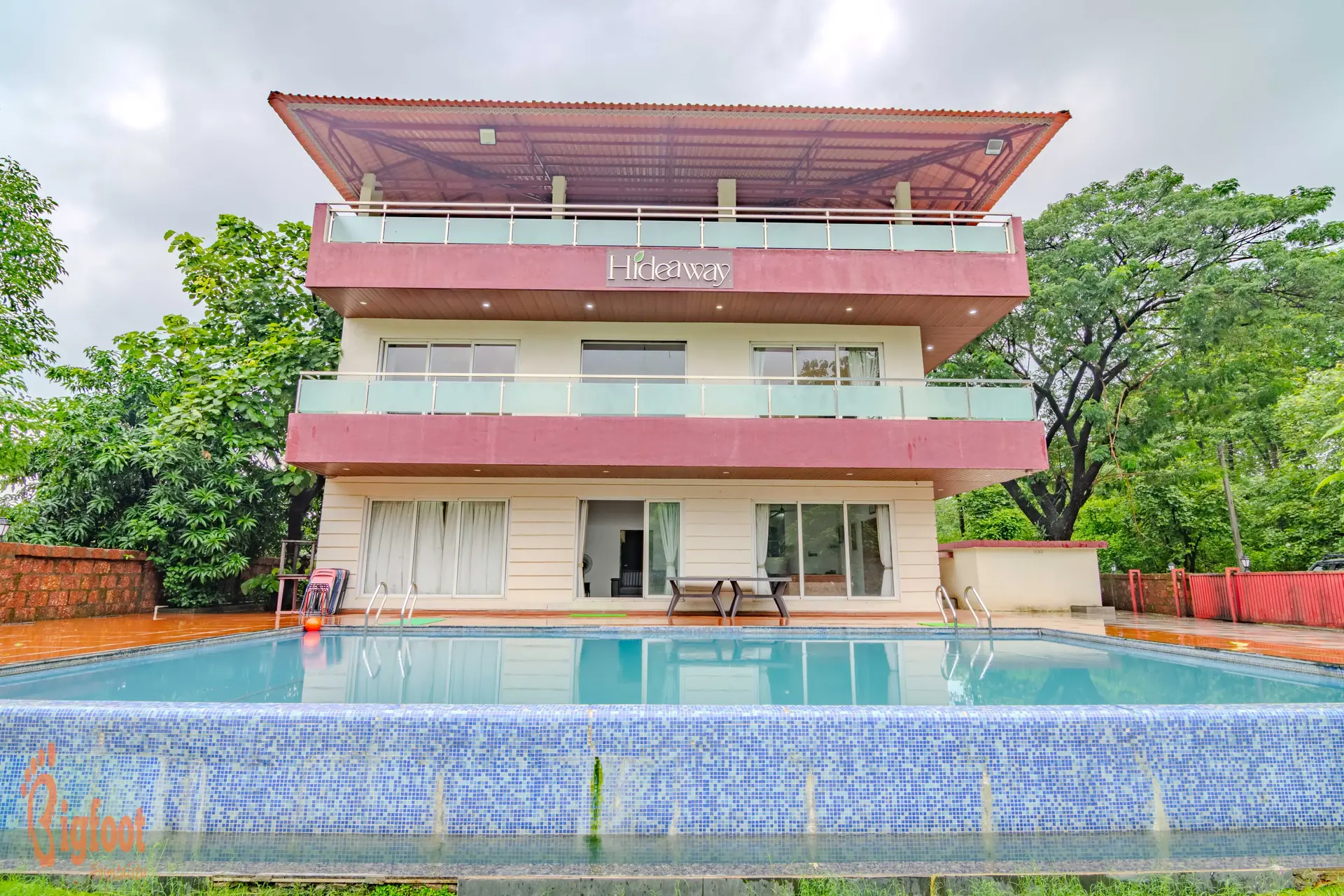 Hideaway Villa in Karjat seen across its private swimming pool at dusk