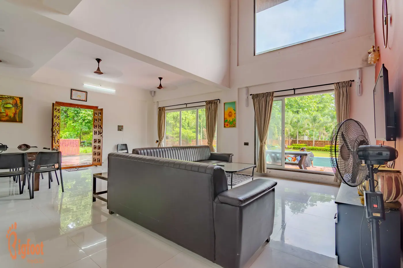 Double-height living hall at Hideaway Villa with sofas, dining area and a terracotta feature wall