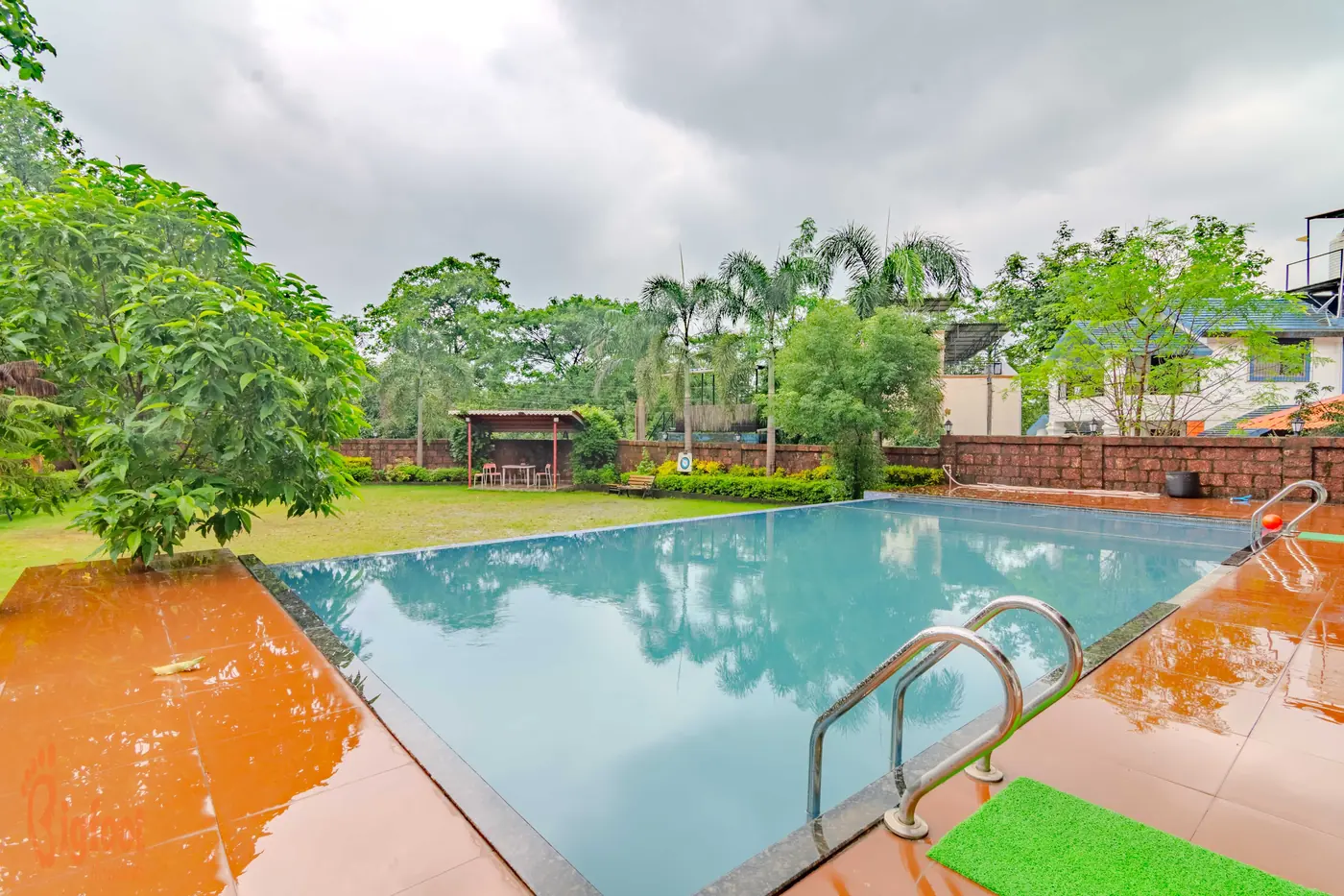The private swimming pool at Hideaway Villa with the lawn and trees behind it